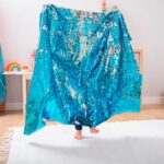 imagen de un niño usando el Set de 2 pañuelos Océano de Tickit a modo de escenario de tela
