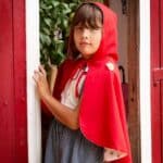 Niña disfrazada con la Capa reversible con capucha de Caperucita Roja