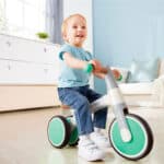 imagen de un niño montado en Mi primer triciclo de equilibrio menta de Hape