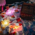 Cubos sensoriales de luz GloPals lilas metidos en varios botes e iluminando un picnic