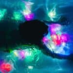 Niña nadando en una piscina llena de Cubos sensoriales de luz GloPals de diferentes colores