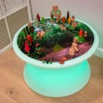 Vinilo para mini mundos temática bosque sobre mesa de luz de agua