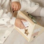 Niña jugando con el triángulo de actividades 3 en 1 incluido en la Caja Juega y aprende 18-24 meses, set de 4 juguetes
