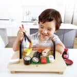 Niño jugando con los palillos de Hoy comemos sushi en una cocina