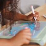 Niña haciendo un dibujo por la parte oscura de la Kidydraw