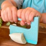imagen del Cuchillo seguro KLYV verde menta - SKÅGFÄ cortando plátano