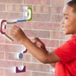 Niño jugando con el Circuito de canicas adhesivo STEM explorers en una ventana