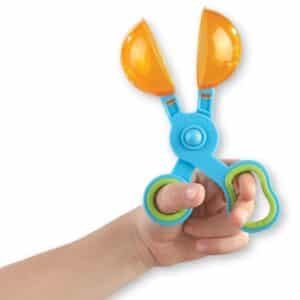 Mano sujetando una Handy Scoopers, tijeras pinzas con pala