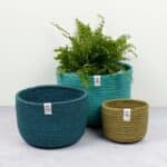 Conjunto de 3 cestos altos de yute Océano uno al lado del otro, el más grande con una planta dentro