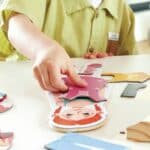 Niño jugando con el Puzzle magnético para vestir con base de madera
