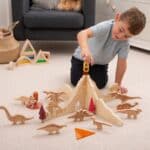 Niño jugando con el Separadores volcán jurásico para minimundos y otras piezas sueltas y figuras de dinosaurios