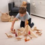 Niño jugando con el Separadores volcán jurásico para minimundos y otras piezas sueltas y figuras de dinosaurios