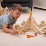 Niño jugando con el Separadores volcán jurásico para minimundos y otras piezas sueltas y figuras de dinosaurios