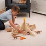 Niño jugando con el Separadores volcán jurásico para minimundos y otras piezas sueltas y figuras de dinosaurios