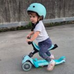 Niña con casco y patinete globber evolutivo en color verde mint