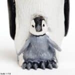 Detalle de la cría de la figura realista de un pingüino emperador con cría de mundo Safari