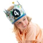 Niña llevando la Corona de cumpleaños reversible de tela superhéroes