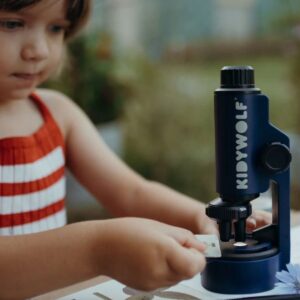 nila mirando en su microscopio como ejemplo de juego STEAM