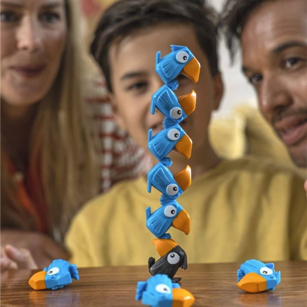 Familia jugando con el Juego de equilibrio de apilar Torre tucán figuras azules