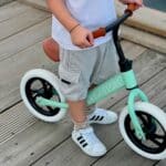 Detalle de un Niño montado en la Bicicleta de equilibrio sin pedales Premium verde menta