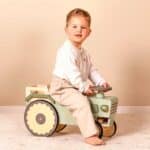 imagen de un niño montado sobre el tractor de madera