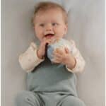 Bebé sonriendo con la Pelota mini blandita Forest Friends de Little Dutch