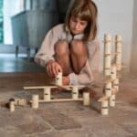 Niña jugando con las Piezas de construcción de madera Woodland de Grapat