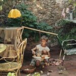 Niño jugando en un jardín con la Tabla de equilibrio y piezas de madera El péndulo de Grapat