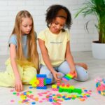 imagen de dos niñas jugando a hacer construcciones con los bloques meli neón