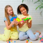 imagen de dos niñas con construcciones hechas con los Bloques Meli Basic Neón travel box 250 piezas