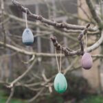 imagen de los 3 huevos colgando de las ramas de un árbol