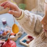 imagen de una niña con uno de los huevos colgando de su dedo