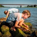 foto de dos niños en un río haciendo una embarcación con el motor