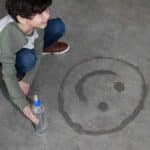 niño pintando sobre hormigón