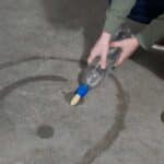 niño pintando sobre hormigón con la botella y el picel enroscable