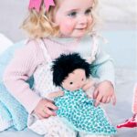 Imagen de niña con muñeca bebé Ari con capazo y accesorios