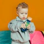 imagen de un niño con la Botella sensorial flotante espiral azul de Petit Boum