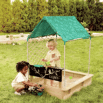 imagen de 2 niñas jugando con la Cabaña con arenero de madera Sandbox de Hape