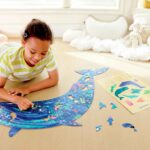 Imagen d euna niña haciendo el Puzzle de suelo brillante de ballena 200 piezas