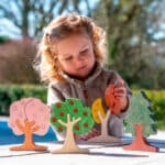 imagen de una niña jugando con los Árboles de madera y gemas Las 4 estaciones de Tickit