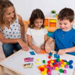 Imagen de familia jugando a Clickies, juego de mesa de destreza manual con policubos
