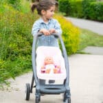 imagen de una niña con la sillita del Cochecito Maxi Cosi 3 en 1 con silla y capazo extraíble