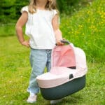 imagen de una niña con el capazo del Cochecito Maxi Cosi 3 en 1 con silla y capazo extraíble