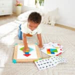 imagen de un niño con las piezas del Laberinto magnético y tablero de Tangram de Hape