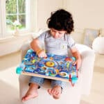 imagen de una niña jugando con el laberinto del Laberinto magnético y tablero de Tangram de Hape
