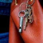 imagen del Mini llavero con silbato de Kikkerland enganchado en un bolso