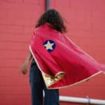 imagen de un niño con la Capa disfraz de Superhéroe reversible talla 5/6 de Great Pretenders por la parte roja
