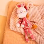 imagen de Lena peluche que brilla en la oscuridad de Lilliputiens sobre una cama