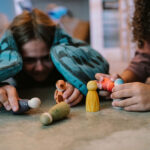 imagen de 2 niñas interactuando con las figuras Grapat animales madera