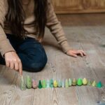 imagen de una niña ordenando las piezas del set Grapat 18 árboles de madera para juego simbólico